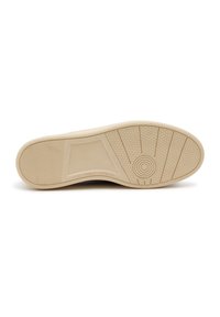 Suola in gomma di colore crema con motivi testurizzati e un accento circolare. Presenta aree piatte e lisce e un design resistente per una buona presa.