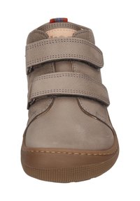Beige Schuh mit zwei Klettverschlüssen, runder Zehenform und strukturiertem Lederoberteil. Verfügt über eine Gummisohle und einen karierten Akzent an der Ferse.