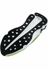Semelle de chaussure avec un design noir et blanc et des accents verts. Surface texturée, découpes circulaires et un logo de marque bien visible.
