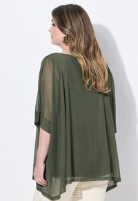 Tunika trasparente verde oliva con maniche corte larghe e forma ad A. Dettagli notevoli includono accenti ricamati sull'orlo.