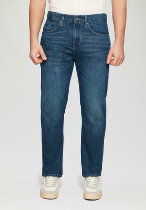Denim jeans in een middelblauwe wassing, met een rechte pasvorm, vijf zakken en subtiele wassingdetails, gecombineerd met witte sneakers.