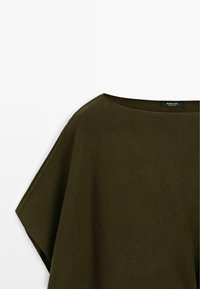 Maglione verde oliva a maniche corte, lavorato a maglia larga, con un ampio scollo rotondo e una piccola etichetta del marchio all'interno del colletto.