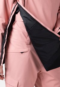 Rosa ytterlager med en svart inredning, med dragkedjestängning. Detaljerad sömnad på ytan och en ficka på den nedre delen.
