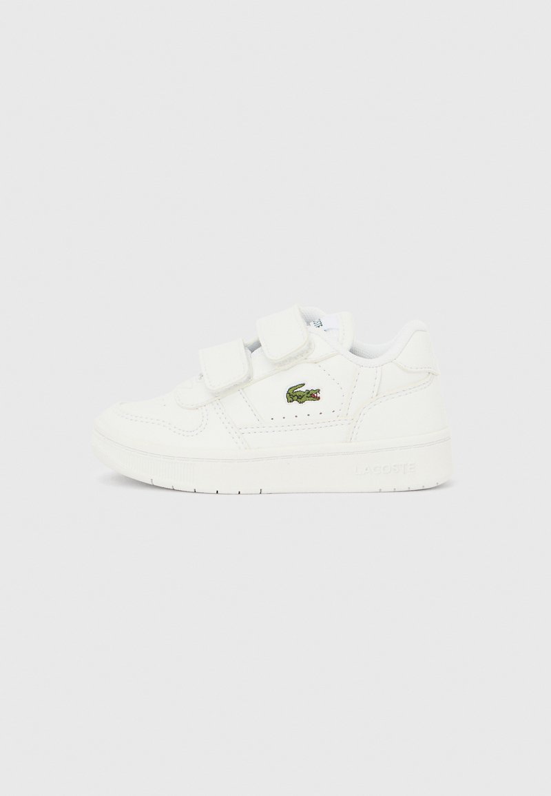 Άσπρο αθλητικό παπούτσι με διπλές λουρίδες Velcro, λεία υφή δέρματος, ανάγλυφο λογότυπο στο πλάι και επίπεδη ελαστική σόλα. Μινιμαλιστικός σχεδιασμός.