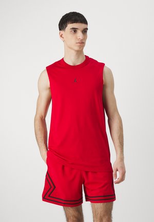 Rød ærmeløs top med Jordan-logo, parret med røde shorts med sorte accenter og striber. Glat stof, atletisk pasform og minimalistisk design.