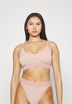 Pink bra and matching high-waisted thong made of smooth fabric. Features an elastic band and thin straps for a minimalist design.
