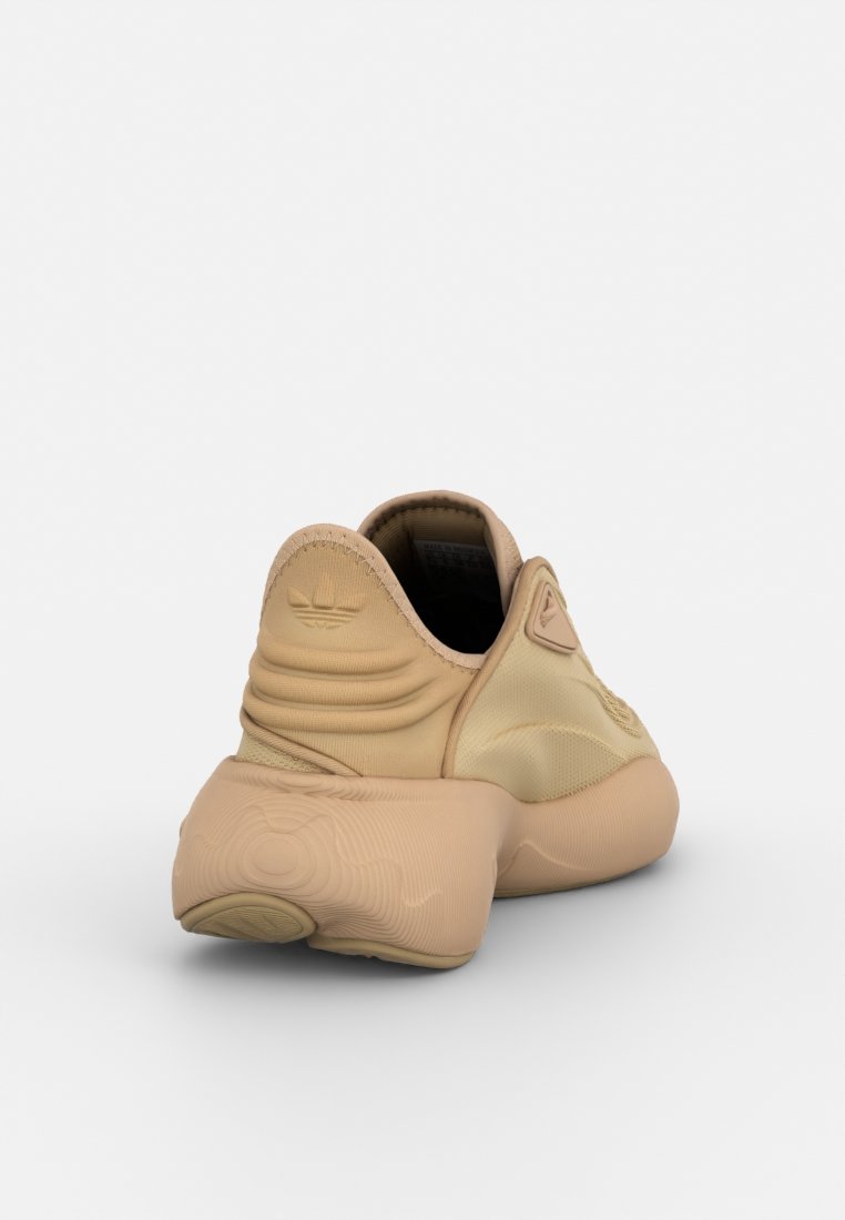 Scarpe sportive beige con una parte superiore morbida e testurizzata e una suola arrotondata e sovradimensionata. Presentano una marca minimalista e un design snello.