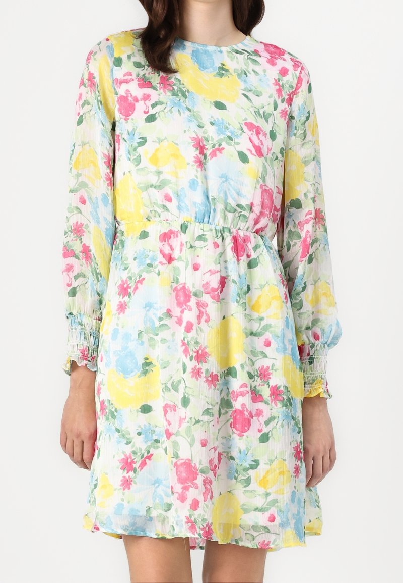 Robe fleurie en tissu léger et texturé avec manches longues, poignets élastiques et taille élastique, présentant des fleurs roses, jaunes et bleues.