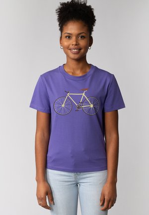 T-shirt en coton violet avec un graphique d'une bicyclette jaune aux accents marron. Manches courtes et col rond.