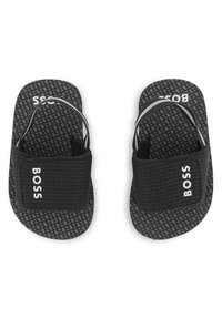 Μαύρα σανδάλια με λουράκια με υφή και πατούσα με σχέδιο. Διαθέτουν λευκό λογότυπο "BOSS" στο λουράκι και ελαστικό σχεδιασμό για άνεση.