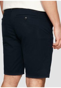 Pantalones cortos de algodón azul marino con corte recto, que cuentan con bolsillos traseros con cierres de botón y un dobladillo ligeramente enrollado en las aberturas de las piernas.
