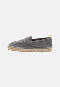 Grå lærred slip-on sko med flettet jutesål og kontrasterende gul detalje på hælen, der har en glat tekstur og minimalistisk design.