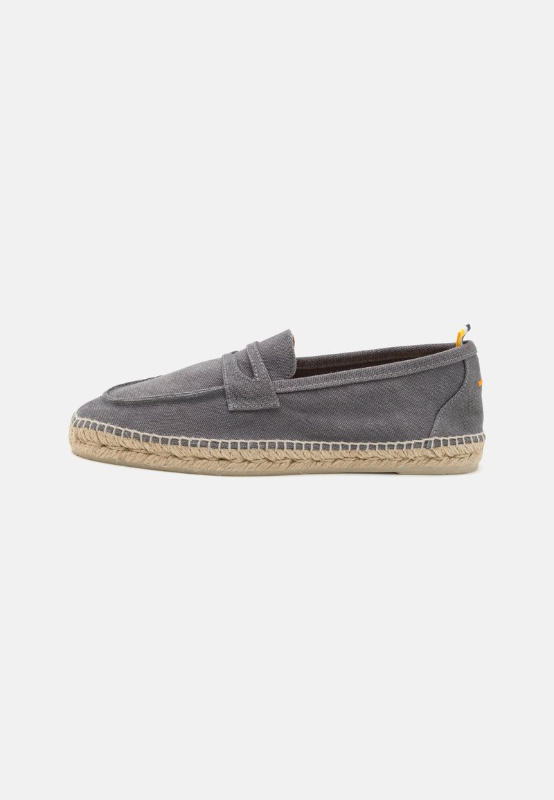 Grå lærred slip-on sko med flettet jutesål og kontrasterende gul detalje på hælen, der har en glat tekstur og minimalistisk design.