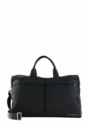 Black nylon duffel bag with two short handles and a detachable shoulder strap. Features front zip pocket and logo detail on the side.