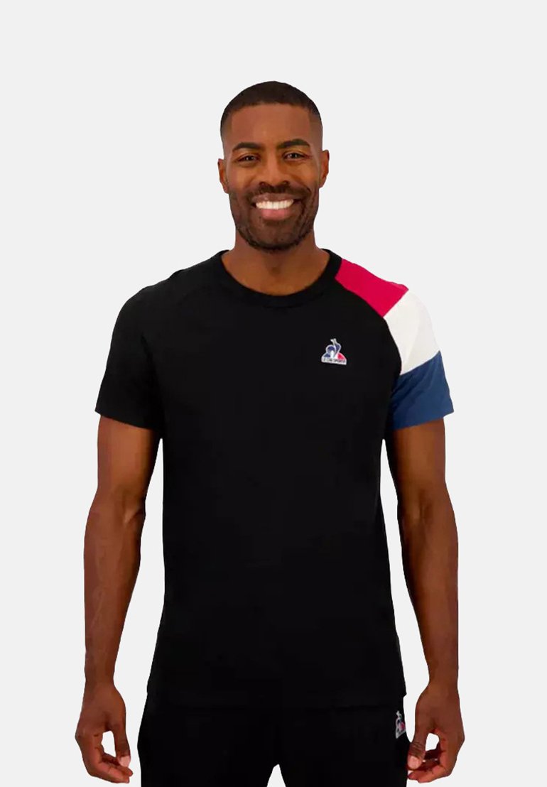 Zwarte T-shirt met korte mouwen, met rode, witte en blauwe schouderaccenten en een klein logo op de borst; zachte stofstructuur.
