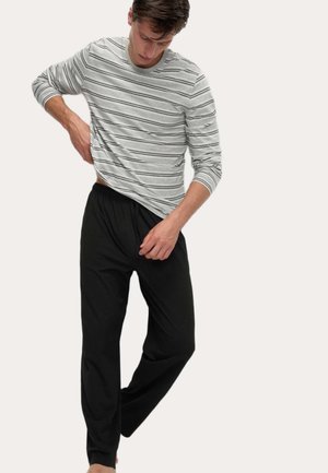 Camicia a maniche lunghe grigia a righe con accenti neri, abbinata a pantaloni neri con coulisse. Tessuto morbido, vestibilità rilassata, design casual.