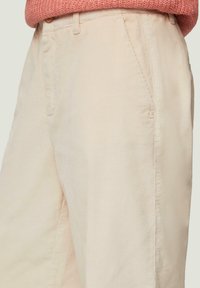 Lichtbeige corduroy broek met verticale strepen, voorzien van zijzakken en een subtiel logo op het onderbeen, textiel met een zachte afwerking.