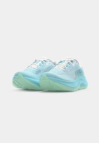 Light blue athletic shoes with mesh upper, textured design, white laces, and green rubber soles. Features brand logo on the side.
