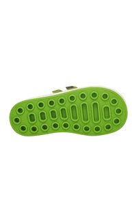 Sole di scarpa in gomma verde con ritagli circolari e ovali, superficie testurizzata e due cinturini regolabili nella parte superiore. Presenta un bordo bianco solido.