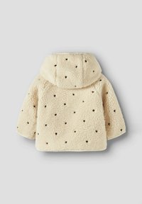 Veste en polaire couleur crème avec capuche, ornée de petits motifs en forme de cœur noirs, texture douce et bords arrondis.