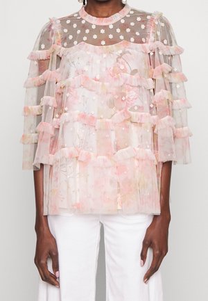 Lichtgewicht sheer top met lagen van ruches in roze en bloemenpatronen, geaccentueerd met kleine witte bloemen en versieringen.