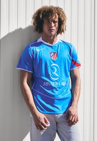 Blue football jersey with short sleeves, featuring a team logo on the left chest, white accents, and "RIYADH AIR" printed centrally.
