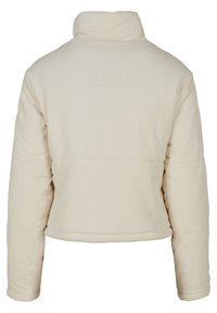 Krämfärgad pufferjacka med ribbad textur, hög krage och kort längd. Har en slät yta med en enkel design och inga synliga detaljer.