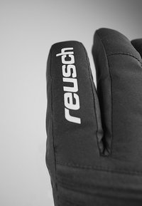 Svarta isolerade handskar med vadderad design; "Reusch"-logotyp i vitt på sidan. Slät yta och avsmalnande fingershape.