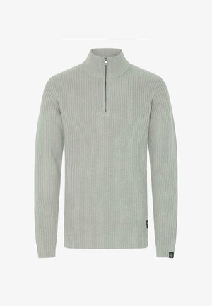 Svijetlosiva pletena majica sa visokim ovratnikom i zatvaranjem na pola municije. Rebrasta tekstura i uske manžete; sadrži malu oznaku na rubu.