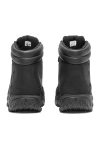 Schwarze Ankle Boots aus Leder mit gepolstertem Kragen, strukturierten Gummisohlen und einem minimalistischen Design. Keine sichtbare Markenkennzeichnung an der Rückseite.