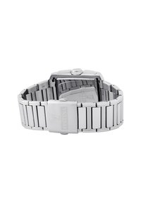 Montre-bracelet en métal argenté avec un boîtier rectangulaire, un bracelet en acier inoxydable et une boucle. Présente un cadran clair et un logo discret.