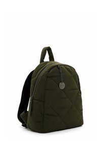Mochila acolchada de color verde oliva con forma redondeada, que cuenta con un bolsillo frontal con cremallera, panel trasero de malla y un asa superior para mayor comodidad al llevarla.