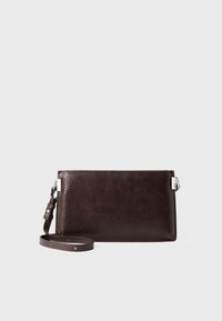 Clutch da polso testurizzato marrone scuro con tracolla removibile e dettagli in metallo argentato su sfondo bianco.