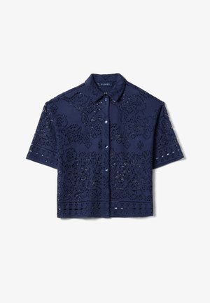 Blusa a maniche corte in crochet blu navy con colletto, chiusura frontale con bottoni e motivi floreali in pizzo su tutta la superficie.