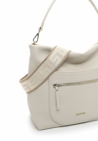 Cream leather handbag with a textured finish, featuring a wide decorative strap with a geometric pattern and a front zip pocket.