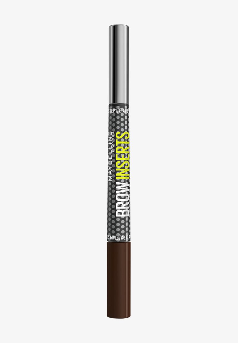 Crayon à sourcils marron avec une étiquette à pois noirs et gris portant l'inscription "Maybelline New York Brow Inserts" et un capuchon argenté.