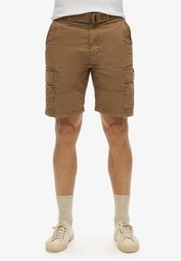 Cargo shorts i lysebrun stof, med fire lommer, et bælte og en afslappet pasform. Tekstureret overflade med synlige sømdetaljer.
