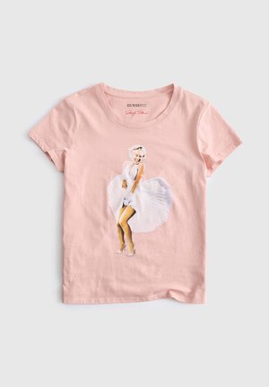 T-shirt rose clair à manches courtes avec une impression d'une femme en robe blanche la tenant vers le bas dans une pose classique.