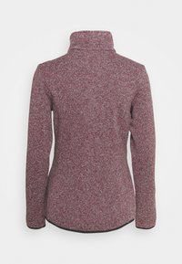 Haut à manches longues en tissu rayé bordeaux et gris avec un col montant et une surface texturée. Présente un ourlet noir aux manches et au bas.