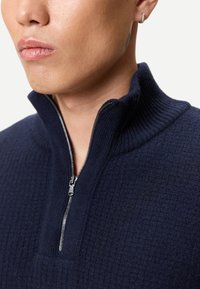 Marinblå zip-hoodie med reveterad struktur, som har en halvdragkedja och en strukturerad krage.