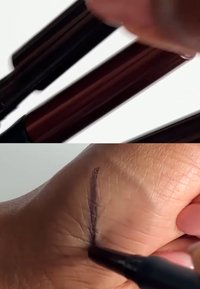 Deux marqueurs brun foncé sont tenus au-dessus d'une main. Une ligne fine est tracée sur la peau, montrant une ligne lisse de couleur violet foncé sur la paume.