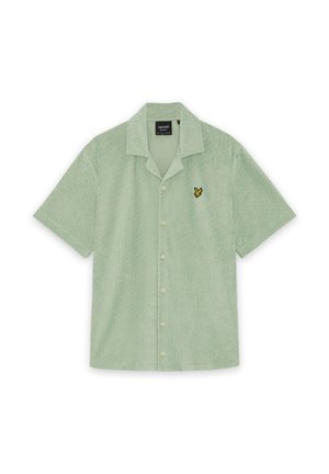 Chemise à manches courtes vert clair avec boutonnière, texture douce et petit logo d'oiseau jaune sur le côté gauche de la poitrine.