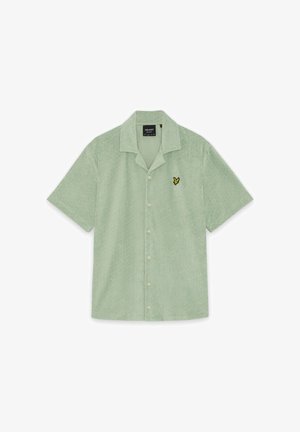 Chemise à manches courtes vert clair avec boutonnière, texture douce et petit logo d'oiseau jaune sur le côté gauche de la poitrine.
