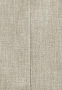 Tissu beige clair avec une finition texturée, présentant un léger motif de tissage. Surface lisse avec un léger éclat.