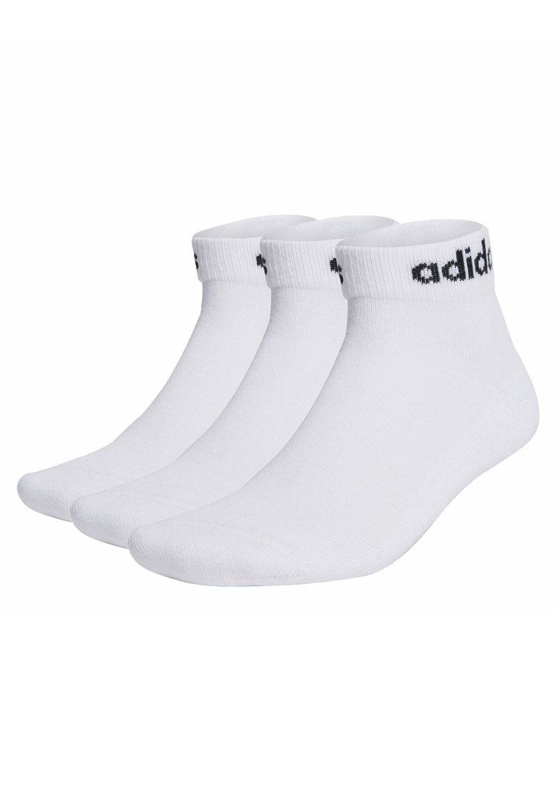 Trois paires de chaussettes de sport blanches avec un logo "adidas" noir sur le bord, de épaisseur moyenne, hauteur de cheville, texture lisse et orteil renforcé.
