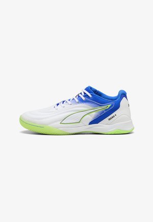 Scarpa sportiva bassa bianca e blu con suola e dettagli verde neon, logo laterale e testo "IBERO V" nell'area del tallone.