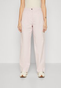 Un pantalon large rose clair à taille haute, avec un devant plissé et une fermeture à un bouton. Tissu lisse avec une finition propre.
