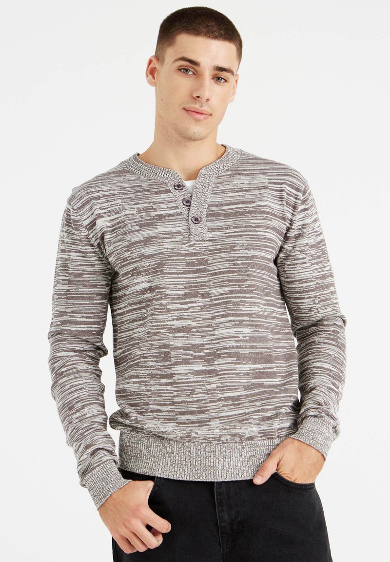 Suéter henley de manga larga a rayas grises y blancas con una tela texturizada, que presenta un cuello redondo y cierre de tres botones en el escote.