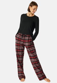 Maglietta nera a maniche lunghe con scollo rotondo; pantaloni scozzesi rossi e neri con tasche, vita con cordino e vestibilità morbida, realizzati in tessuto morbido.