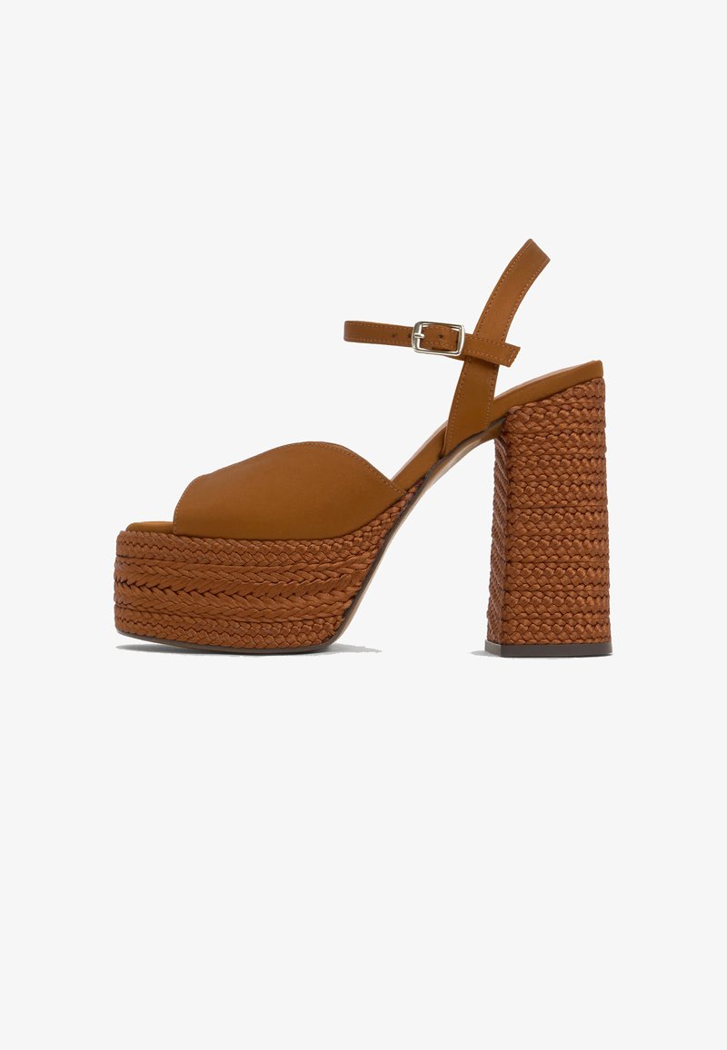 Sandale à talons hauts marron avec une épaisse plateforme tressée et un talon bloc, avec une bride en cuir à la cheville munie d'une boucle argentée.